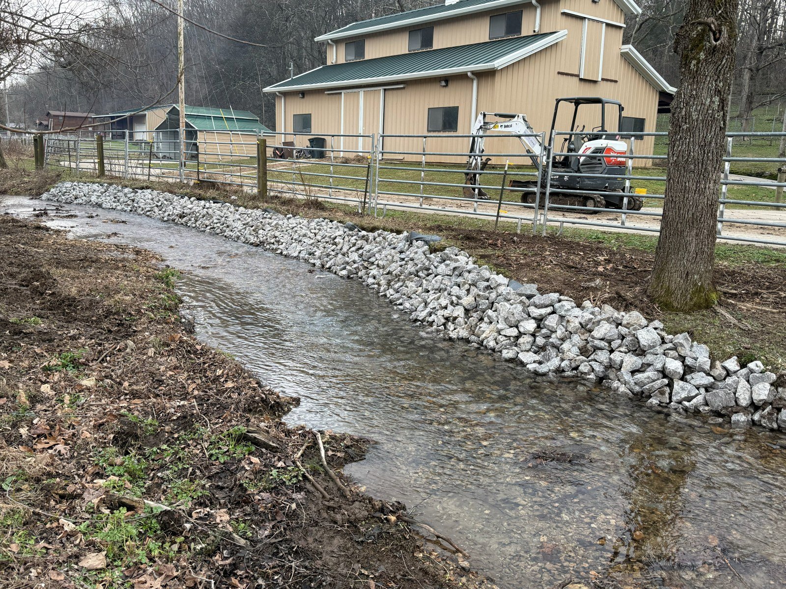 After: creek bank stabilized with riprap stone