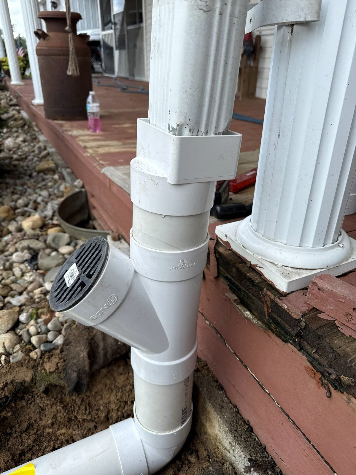 Downspout drain extension pipe installed along a foundation